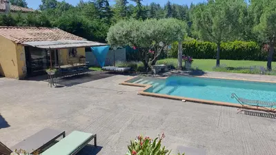 a swimming pool in a yard next to a house at la chambrette in Lincel