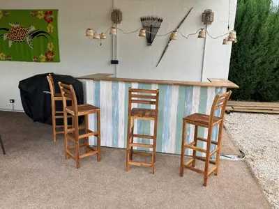 a group of four wooden chairs around a bar at Halte Vintage. A l’ombre du saule. in Carpentras