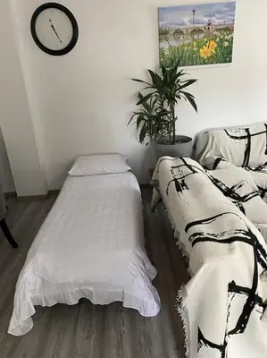 two beds in a room with a clock on the wall at SPA jardin privé T3 indépendant dans Villa in Morières-lès-Avignon