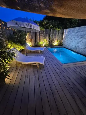 a deck with a pool and chairs and an umbrella at Le Cocoon - Jacuzzi, Sauna et Piscine privée in Carpentras