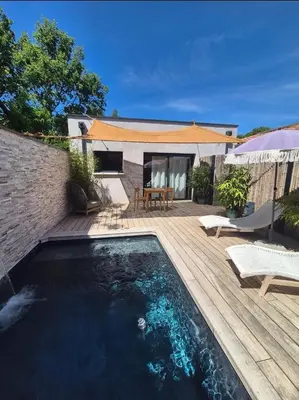 a backyard with a swimming pool and a wooden deck at Le Cocoon - Jacuzzi, Sauna et Piscine privée in Carpentras