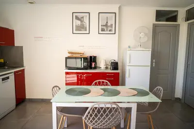 a kitchen with a table and chairs and a microwave at Ô Coeur Des Ocres in Roussillon