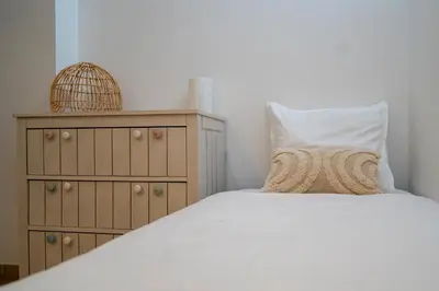 a bedroom with a white bed and a dresser at Ô Coeur Des Ocres in Roussillon
