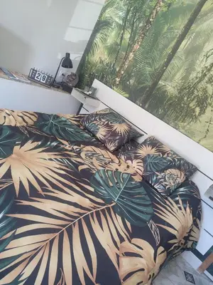 a bedroom with a bed with a tropical print at Studio Zen Miramas in Miramas