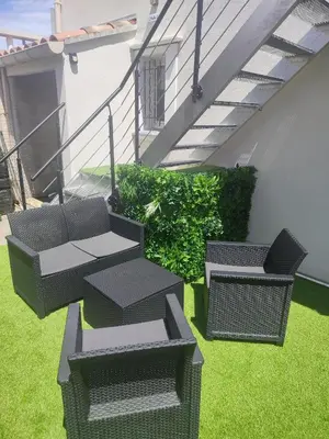 a patio with chairs and tables on a lawn at Studio Zen Miramas in Miramas