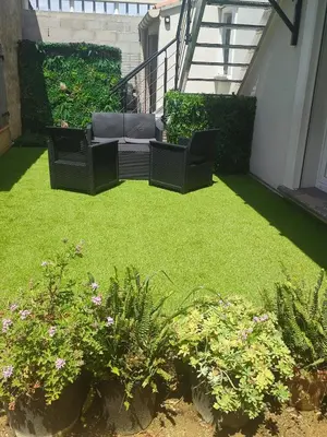 a patio with a lawn with chairs and plants at Studio Zen Miramas in Miramas