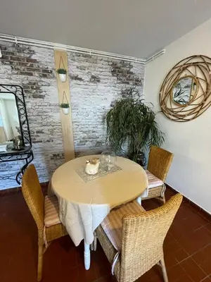 a dining room with a table with chairs and a mirror at En Provence chez Valérie in Cavaillon
