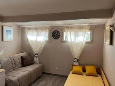 a living room with a couch and two windows at Villa le 62 Cazan in Vernègues