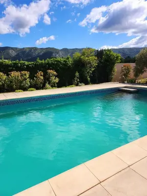 a large swimming pool with blue water at Le Clos Renaissance in Oppède