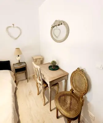 a bedroom with a table and chairs and a mirror at Le Clos Renaissance in Oppède