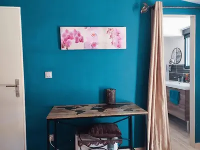 a table in a room with a blue wall at Maisonnette en campagne au calme in Carpentras