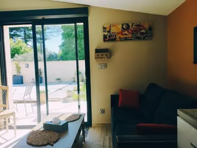 a living room with a couch and a glass door at Maisonnette en campagne au calme in Carpentras