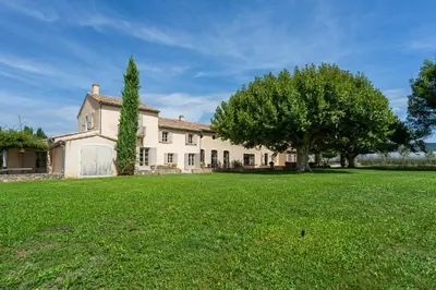 a large house with a tree in the yard at Les Deux Mas in Lagnes