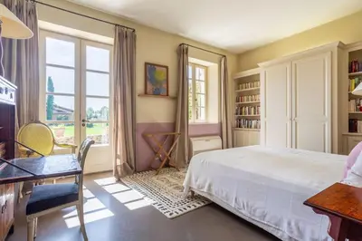 a bedroom with a bed and a desk and a window at Les Deux Mas in Lagnes
