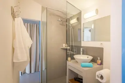 a bathroom with a sink and a glass shower at Maison Sebastien in Saint-Michel-lʼObservatoire