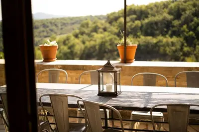 a table with chairs and a lantern on a balcony at Maison Sebastien in Saint-Michel-lʼObservatoire