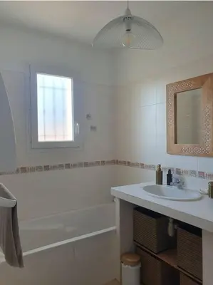 a bathroom with a sink and a tub and a mirror at Maison en Provence avec jacuzzi in Peyrolles-en-Provence