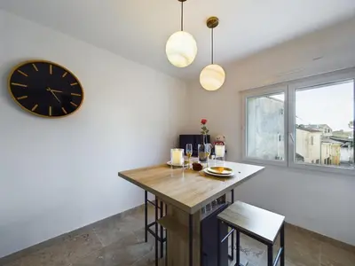 a dining room with a table and a clock at Pic love, 2 personnes jacuzzi in Châteaurenard