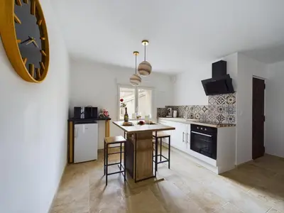 a kitchen with a large clock on the wall at Pic love, 2 personnes jacuzzi in Châteaurenard