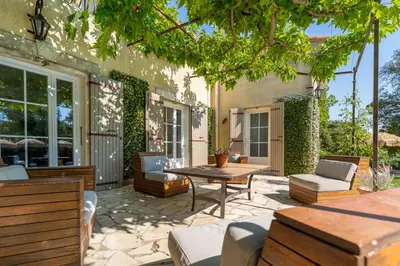 an outdoor patio with a table and chairs at Provencal bastide with heated pool near Alpilles and Luberon in Vernègues