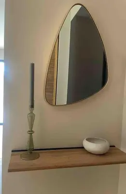 a mirror and a vase on a shelf with a candle at Gîte Un air de Provence in Eyguières