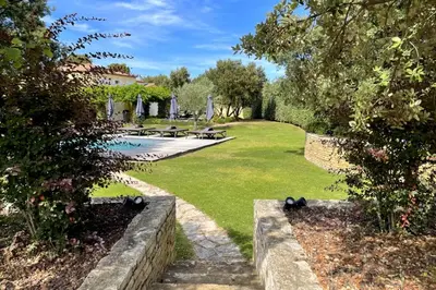 a garden with a pool and benches and trees at Villa Oasis Luxury and Relaxation in Provence in Lambesc