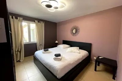 a bedroom with a bed with white sheets and a mirror at Villa Oasis Luxury and Relaxation in Provence in Lambesc