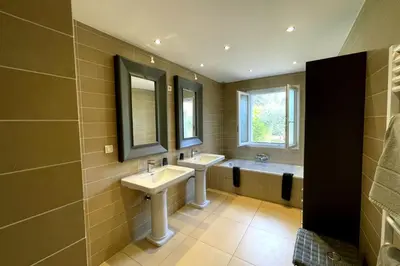 a bathroom with two sinks and a tub and two mirrors at Villa Oasis Luxury and Relaxation in Provence in Lambesc