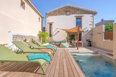 a pool with chaise lounge chairs next to a house at KM2 in Bédoin