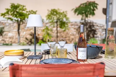 a table with a bottle of wine and glasses on it at KM2 in Bédoin