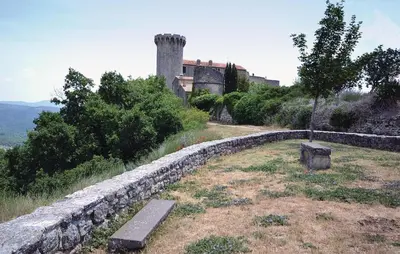 a bench sitting on a hill next to a stone wall at 1 Bedroom Lovely Home In Viens in Viens