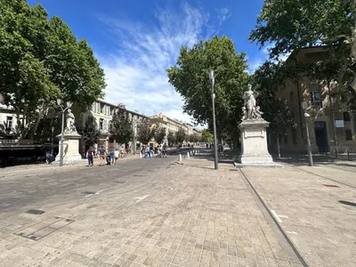 a street with a statue in the middle of a city at Charmant studio le clos d'Aix parking privé gratuit et piscine in Aix-en-Provence