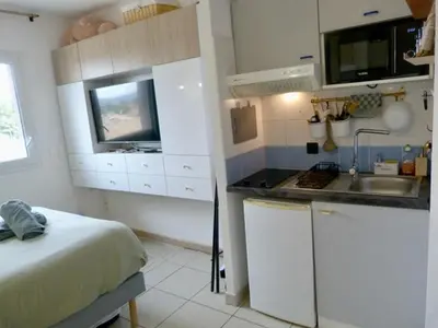 a small kitchen with a bed and a sink at Charmant studio le clos d'Aix parking privé gratuit et piscine in Aix-en-Provence