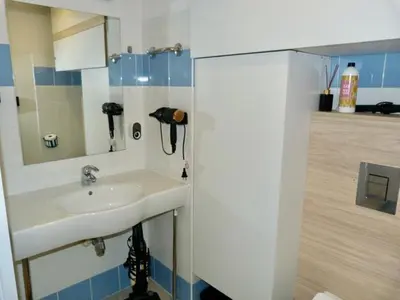 a bathroom with a sink and a mirror at Charmant studio le clos d'Aix parking privé gratuit et piscine in Aix-en-Provence