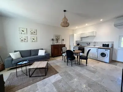 a living room with a couch and a table and chairs at Le Platane Maison climatisée avec piscine in Monteux