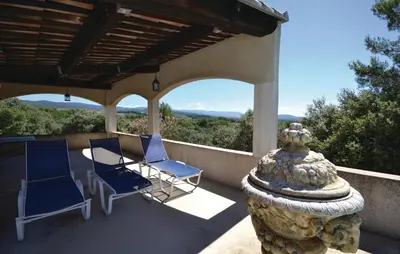 a porch with two chairs and a stone pillar at Awesome Home In Joucas With Kitchen in Joucas