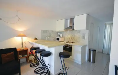 a kitchen with a counter and stools in a room at Awesome Home In Joucas With Kitchen in Joucas