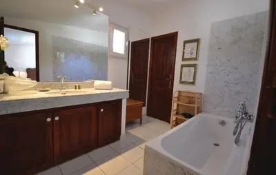 a bathroom with a tub and a sink and a bath tub at Awesome Home In Joucas With Kitchen in Joucas