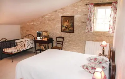 a bedroom with a bed and a table with a desk at Belle Maison À Lacoste in Lacoste