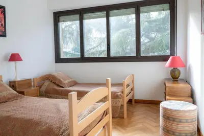 a bedroom with a bed and two windows at T3 Centre ville Aix-en-Provence in Aix-en-Provence