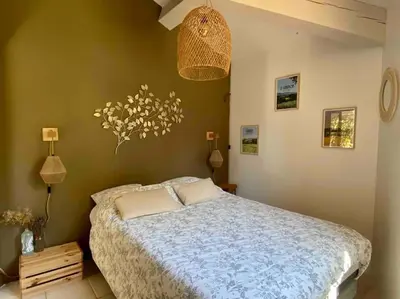 a bedroom with a bed and a chandelier at Charmante dépendance avec piscine en Provence in Le Puy-Sainte-Réparade