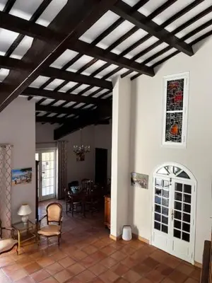 a living room with a table and chairs and a ceiling at Domaine des Figons in Éguilles