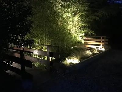 a fence at night with a garden and plants at Le Mas Mérindol Gîte Cerise in Loriol-du-Comtat