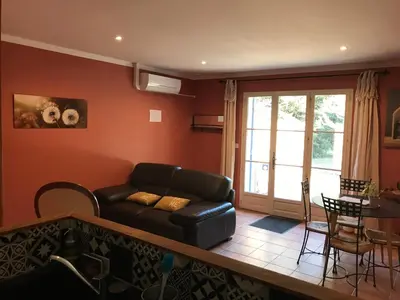 a living room with a couch and a table at Le Mas Mérindol Gîte Cerise in Loriol-du-Comtat
