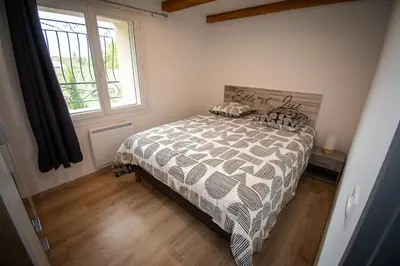 a bedroom with a bed with a comforter and a window at Appartement moderne à Avignon avec piscine partagée in Avignon