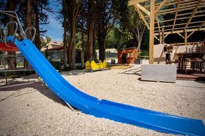 a playground with a blue slide in a park at Appartement moderne à Avignon avec piscine partagée in Avignon