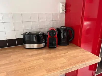 two appliances sitting on a counter next to a refrigerator at Le l'islois- Park&Piscine in LʼIsle-sur-la-Sorgue