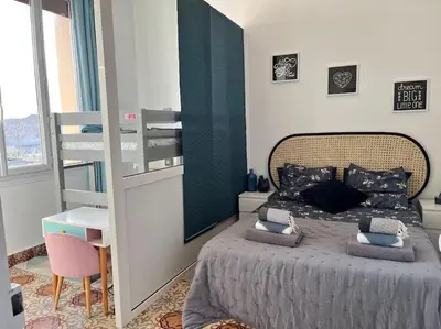 a bedroom with a bed and a loft bed and a desk at Le l'islois- Park&Piscine in LʼIsle-sur-la-Sorgue