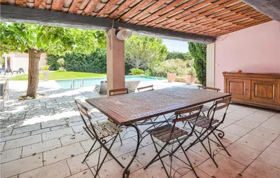 a table and chairs on a patio with a pool at Nice Home In Eyguieres With Wifi in Eyguières