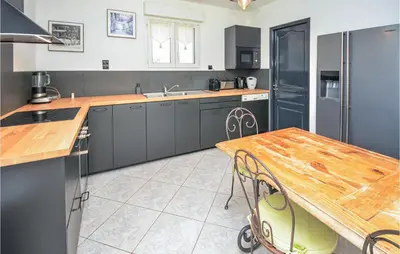 a kitchen with a wooden table and a wooden counter top at Nice Home In Eyguieres With Wifi in Eyguières